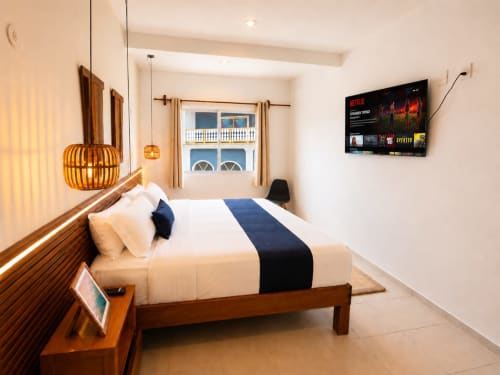 Suite moderna en Hotel Isla Mujeres Centro con cama queen, vista a la ciudad, muebles de madera y TV con Netflix
