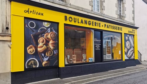 Façade jaune éclatant de la boulangerie-pâtisserie artisanale à Cléder, France avec pâtisseries exposées