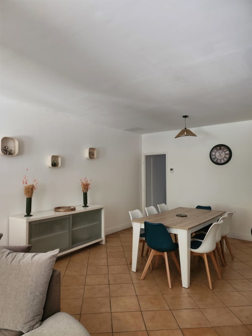 Modern dining area in Clairette cottage at Domaine De Poulharies, Carcassonne, with wooden table, mixed seating, and wall