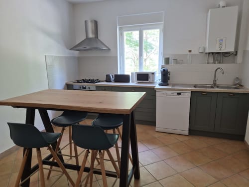Modern kitchen and dining area in Clairette cottage at Domaine De Poulharies, Carcassonne, with wooden table, black chairs,