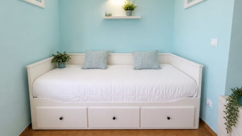 Cama diurna blanca moderna con cojines azules estampados en habitación azul claro en Holidays Costa Brava, apartamento Empuriabrava