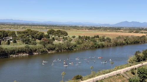 Vista del río Empordà con paddleboarders y vegetación verde, apartamentos Holidays Costa Brava