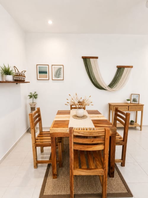 Comedor moderno en suite del Hotel Isla Mujeres Centro con mesa de madera, sillas, plantas y decoración costera en paredes blancas