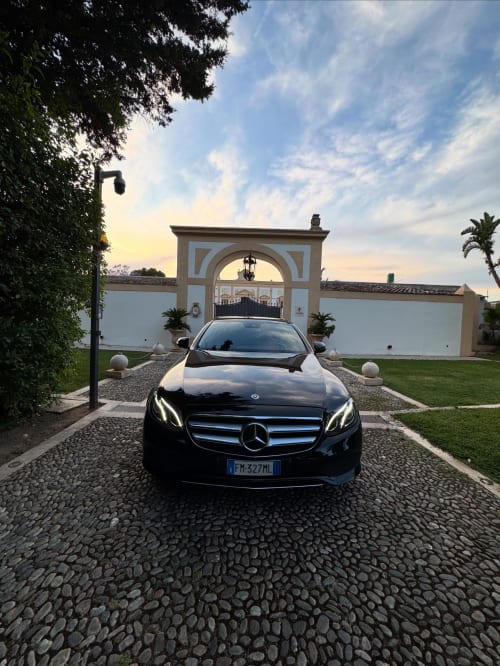 Black Mercedes sedan in driveway at Liberty Palace B&B, Palermo with elegant arched gatehouse
