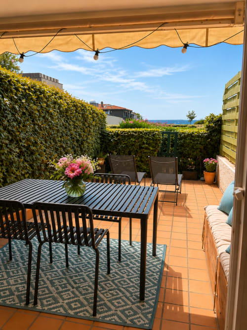Terrasse bord de mer à La Loge Du Bassin avec table de repas, vue sur mer et jardin paysagé à Lège Cap Ferret