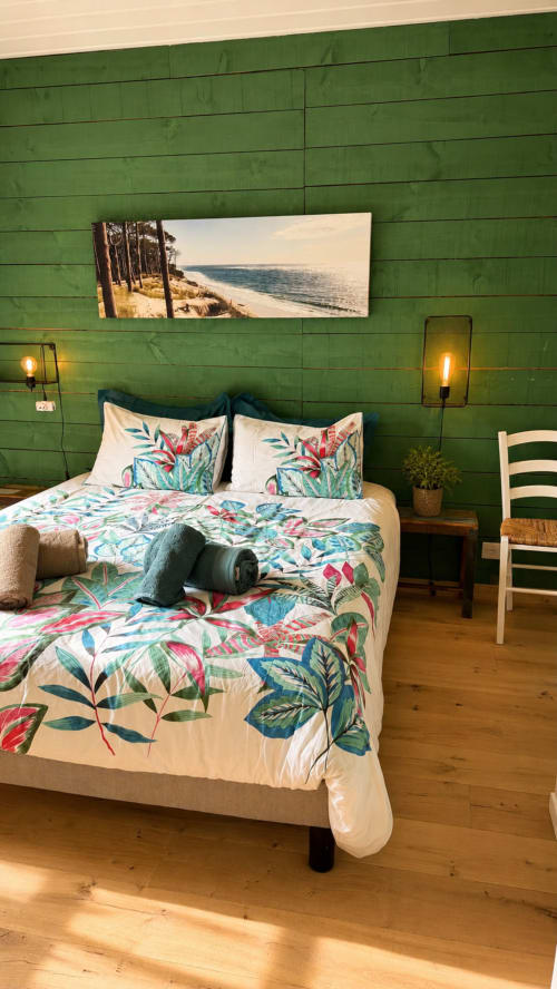 Chambre avec parure florale à la villa La Loge Du Bassin à Lège-Cap-Ferret, murs en lambris vert, décoration côtière et design moderne