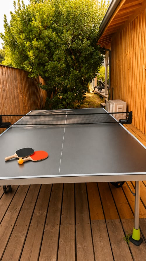 Table de ping-pong avec raquettes et balles sur la terrasse en bois de la villa La Loge Du Bassin à Lège-Cap-Ferret