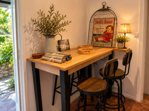 Bureau rustique au plateau en bois et cadre métal noir dans le cottage de Grignan, avec chaises, lampe et décoration