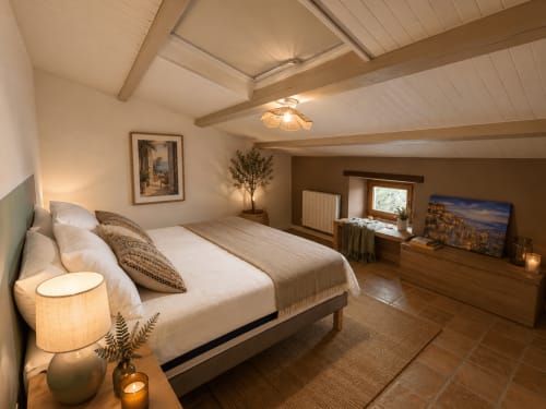 Chambre spacieuse d'Entre Ciels et Lettres à Grignan avec poutres apparentes, literie blanche et vue sur les montagnes