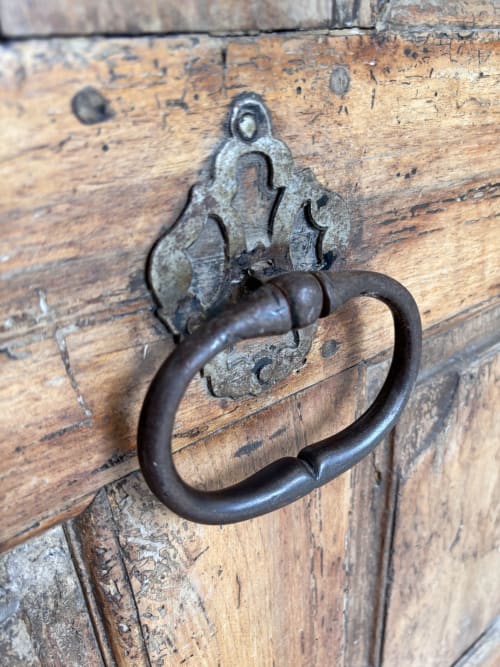 Poignée de porte en fer rustique et ornement métallique sur porte en bois vieilli au gîte Entre Ciels et Lettres à Grignan, France