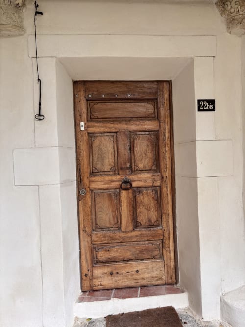 Porte d'entrée en bois du gîte Entre Ciels et Lettres à Grignan, façade en pierre blanche, numéro 22bis