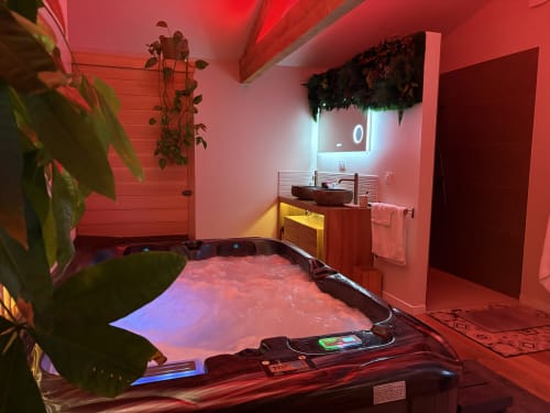 Suite spa moderne avec éclairage ambiant rouge, sauna et piscine intérieure au L'Olive Sacrée en Provence, France