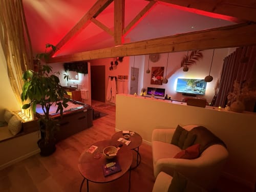 Suite contemporaine avec éclairage ambiant rouge, sièges confortables et espace de divertissement à la suite de luxe de Provence