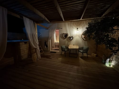 Terrasse élégante à Suite l'Olive Sacrée en Provence avec terrasse en bois, espace repas et décor romantique aux cœurs