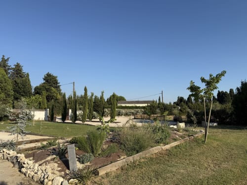 Jardins du Domaine Mas Lafleur avec cyprès, pelouse soignée et vue sur la campagne à Châteaurenard