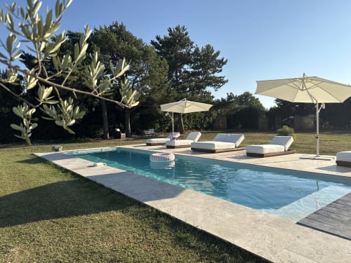 Zone de piscine du Domaine Mas Lafleur à Châteaurenard avec transats, parasols et jardins paysagés