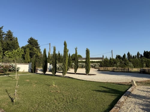 Les jardins du Domaine Mas Lafleur à Châteaurenard avec pelouse soignée, cyprès et allée gravillonnée menant à la maison principale
