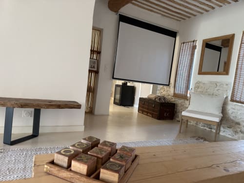 Spacieuse chambre au Domaine Mas Lafleur avec poutres en bois, écran de projection, décor rustique et équipements modernes