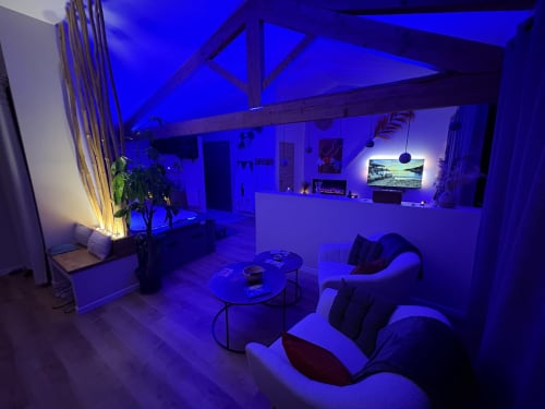 Suite moderne avec éclairage ambiant bleu, salon confortable et espace divertissement à Suite & Duplex Provence