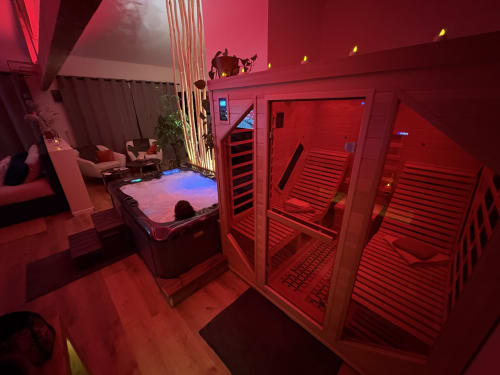 Suite spa luxueuse aux éclairages rouges avec cabines de sauna infrarouge et bain à remous à l'hôtel Suite & Duplex à Cabannes