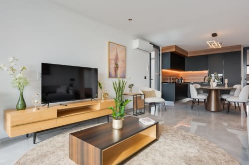 Sala de estar moderna com televisão e cozinha integrada