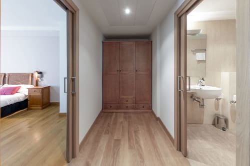 Couloir lumineux de l'hôtel Casa Azcona avec penderie, chambre et salle de bain visibles à Zizur Mayor