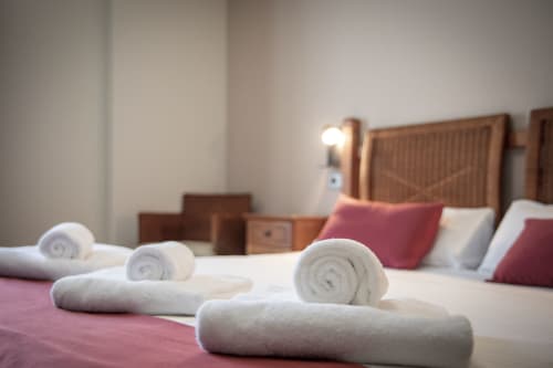 Serviettes blanches roulées sur le lit de l'hôtel Casa Azcona à Zizur Mayor avec oreillers et vue sur les montagnes