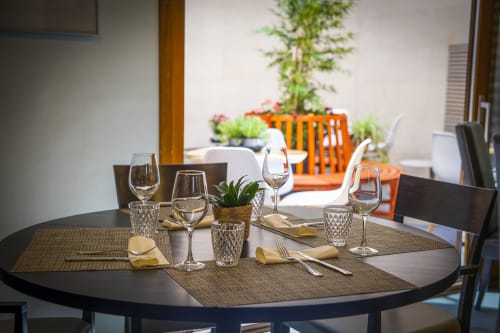 Table de salle à manger élégamment dressée à l'hôtel Casa Azcona à Zizur Mayor avec verres, couverts et plantes en pot