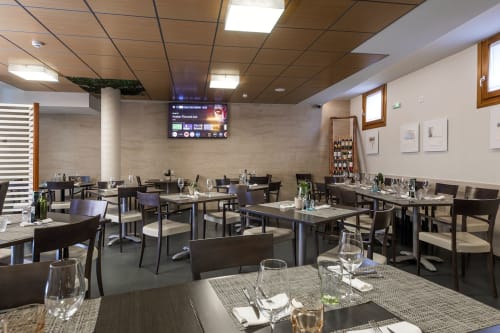 Salle à manger du restaurant Casa Azcona à Zizur Mayor avec tables, chaises et présentation de vins