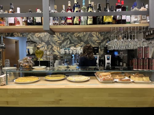 Comptoir du bar Casa Azcona avec pâtisseries, boissons et sélection de vins à Zizur Mayor