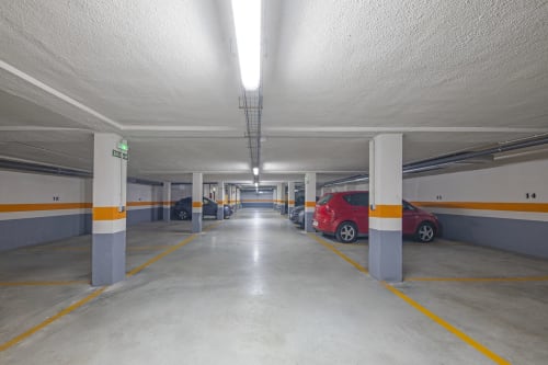 Parking souterrain de l'hôtel Casa Azcona à Zizur Mayor avec voitures garées et emplacements numérotés