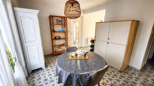 Spacieuse salle à manger de la villa Ô de Mer Sangatte avec table ronde, rangements bois et vue sur le jardin près de la plage