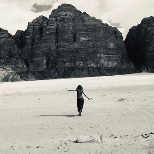 Woman in desert landscape with dramatic rock formations near Treviso, Italy