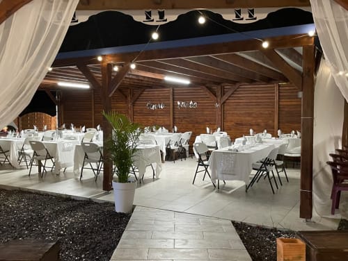 Salle de réception élégante aux Créolines, Sainte-Luce avec tables dressées, chaises blanches et éclairage ambiant