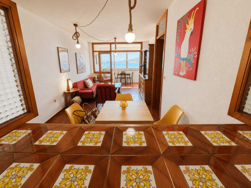 Apartamento Holibai en Baiona con suelo de azulejos decorativos, comedor y vistas al mar desde las ventanas del salón