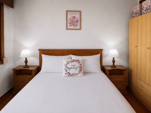 Acogedora habitación en Holibai Baiona con cama de madera, ropa de cama blanca y decoración de almohadas con tema primaveral