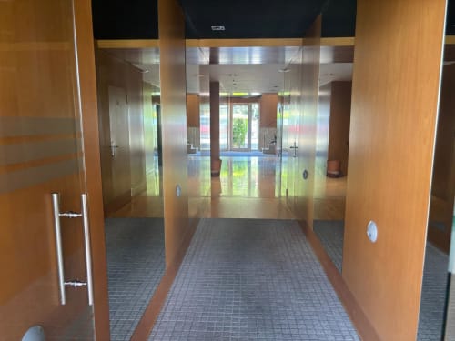 Pasillo moderno del hotel Holibai en Baiona con paneles de madera y puertas de cristal