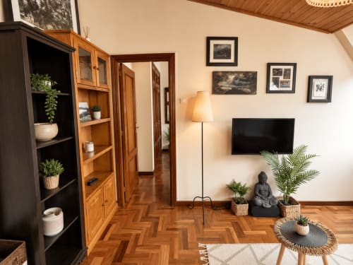 Acogedor salón de apartamento en Baiona con suelo de parqué en espiga, televisor, plantas y cuadros enmarcados