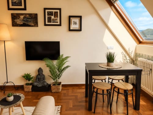 Moderno apartamento en ático de Baiona con claraboya, TV de pantalla plana, mesa comedor con sillas, plantas y parquet en espiga
