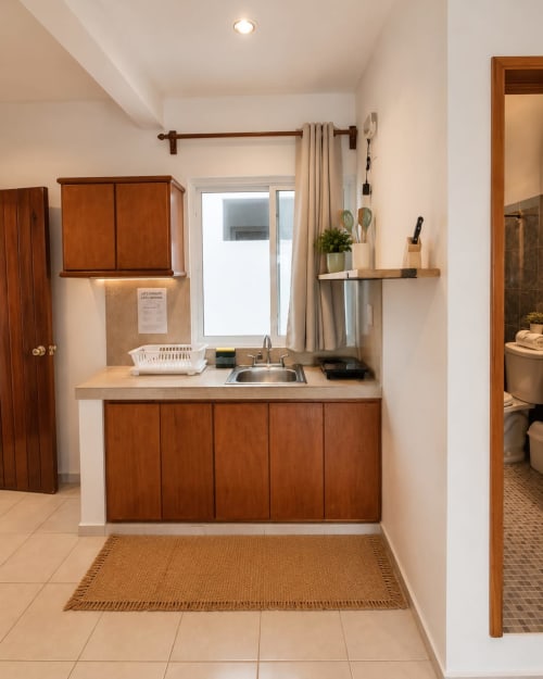 Cocina compacta con gabinetes de madera, lavamanos y estufa en Suite 9 del Hotel Isla Mujeres Centro, Isla Mujeres