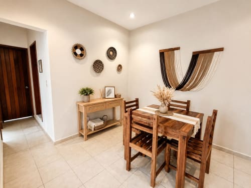 Zona de comedor Suite 11 con muebles de madera y decoración de pared tejida en Hotel Isla Mujeres Centro, México