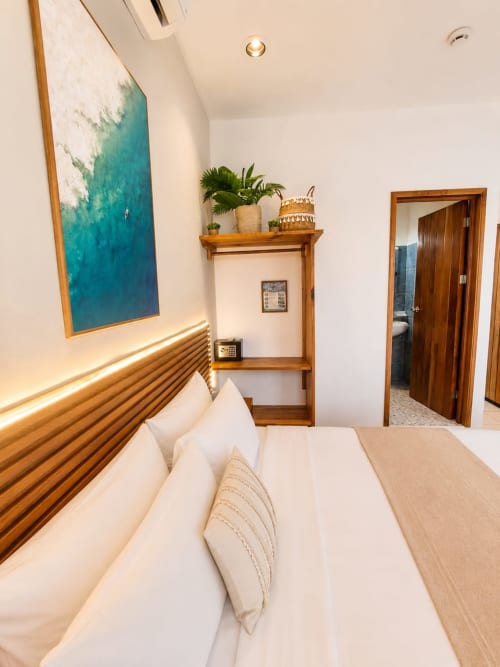 Habitación moderna en Hotel Isla Mujeres Centro con arte de vista al océano, cabecero de madera, plantas en maceta en repisa y