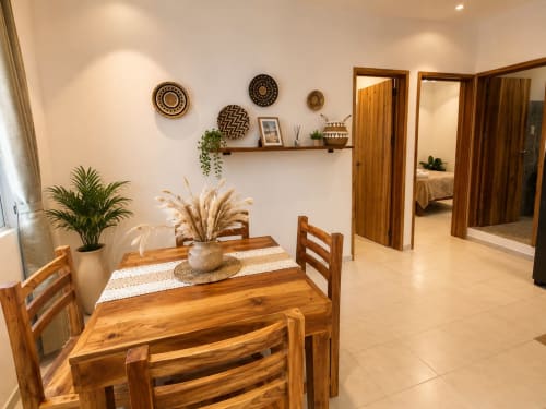 Comedor moderno en suite del Hotel Isla Mujeres Centro con mesa de madera, sillas y repisas decorativas en Isla Mujeres,