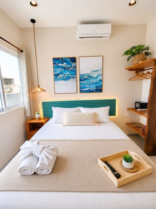 Habitación moderna en Hotel Isla Mujeres Centro con cabecero verde, obra de arte con vistas al océano, estantería de madera y vistas al mar