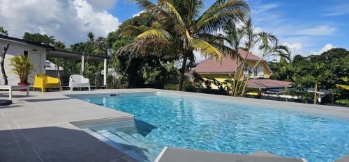 Luxuriöser Swimmingpool in der Habitation Villa Les Cassias in Petit-Bourg, Guadeloupe mit Palmen und Liegestühlen