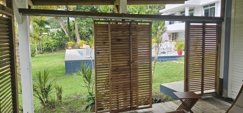 Schattige Terrasse mit Holzjalousietüren mit Blick auf die gepflegten Gärten der Habitation Villa Les Cassias, Petit Bourg Guadeloupe