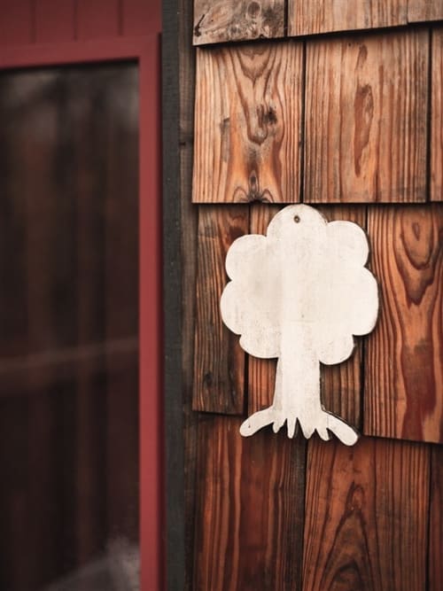 White decorative tree ornament on wooden wall at Les Murmures du Bois bed and breakfast in France