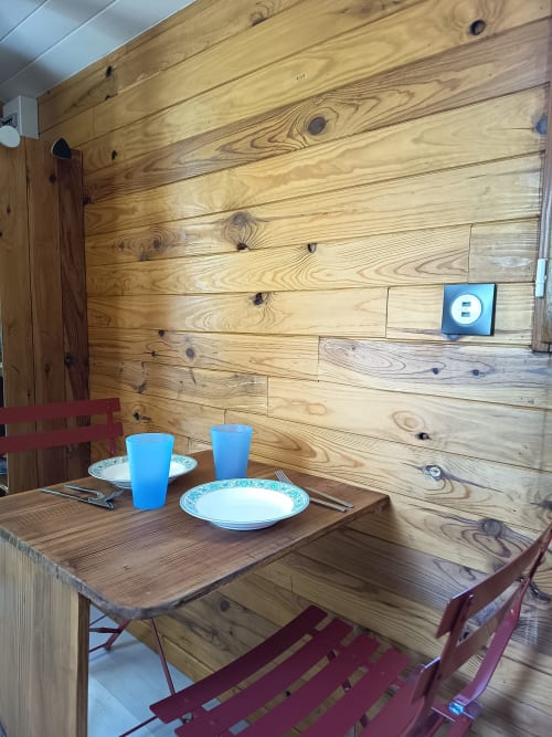 Table de salle à manger rustique en bois dressée pour deux à La Roulotte, Maison Maliga, Saint-Pierre-de-Curtille