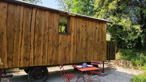 Caravane en bois avec espace repas en plein air dans le jardin de la Maison Maliga, Saint-Pierre-de-Curtille