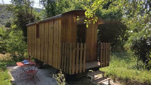 Roulotte de glamping en bois avec terrasse nichée dans le jardin de Maison Maliga, Saint-Pierre-de-Curtille